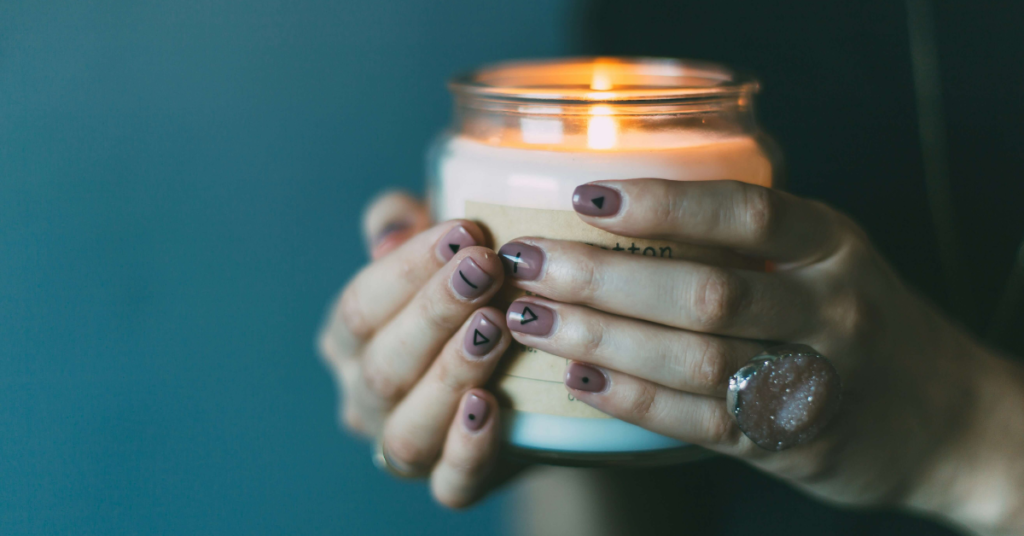 Close-up of hands holding a candle, symbolizing hope and resilience for military spouses facing emotional abuse.